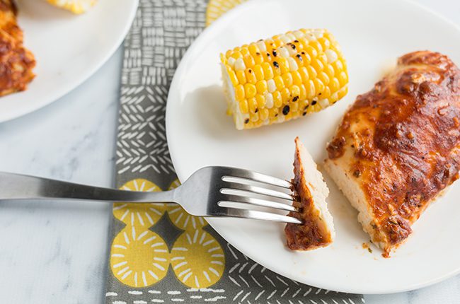 Overhead picture of bbq ranch baked chicken breasts on white plate