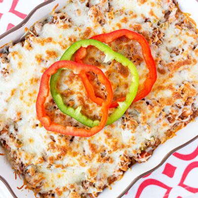 Overhead picture of a stuffed pepper casserole in a white baking dish sitting on pink and white napkin