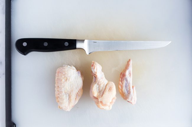 The different pieces of the chicken wing laying on a cutting board