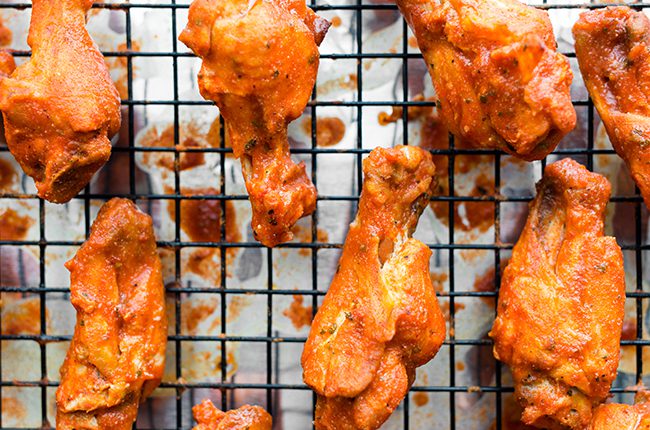 Up close picture of buffalo chicken wings on a wire rack