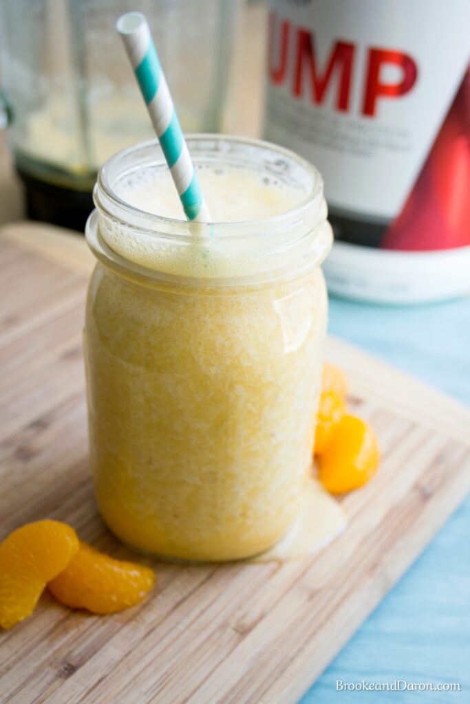 Orange smoothie in jar on cutting board