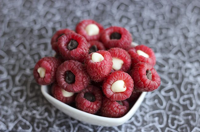 Overhead picture of a white bowl of chocolate raspberry poppers with white and dark chocolate chips