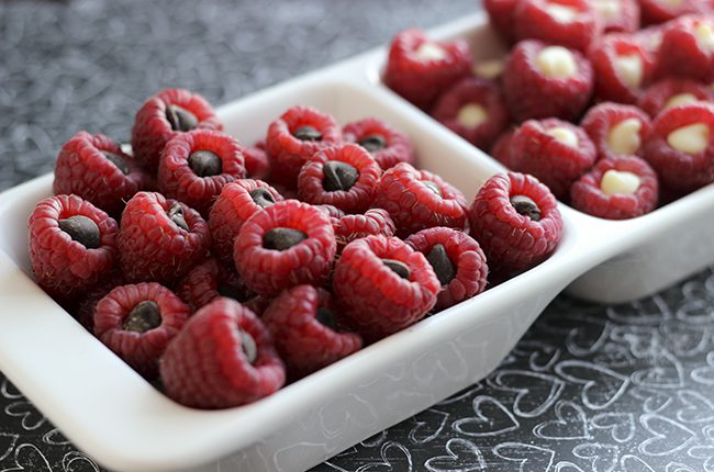 A white serving tray divided in two filled with chocolate raspberry poppers snacks