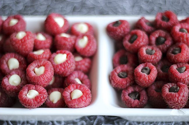 A white serving tray divided in two filled with chocolate raspberry poppers snacks
