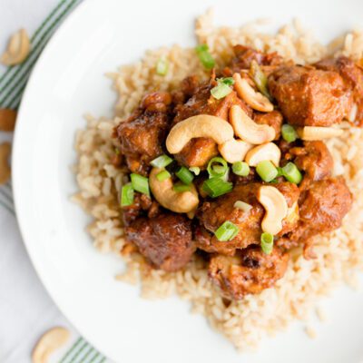 Overhead picture of a white bowl with brown rice and cashew chicken recipe