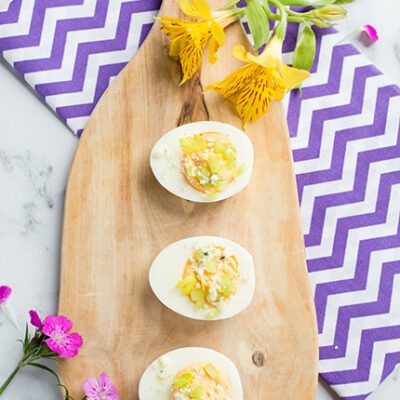 buffalo deviled eggs on a cutting board with a purple and white towel