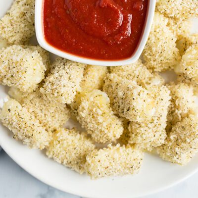 Overhead picture of white plate full of healthy baked mozzarella sticks
