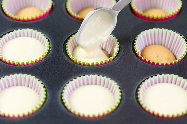 Cherry mini cheesecakes being poured into muffin tins