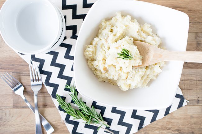 Large white bowl filled with potato parsnip mash on black and white napkin