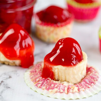 Overhead picture of mini cherry cheesecakes on a counter