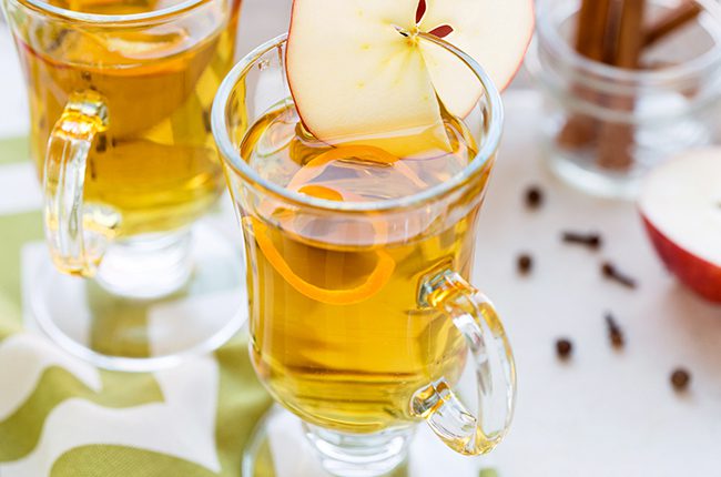 Two glass mugs of hot apple cider