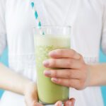Woman in white dress holding smoothie