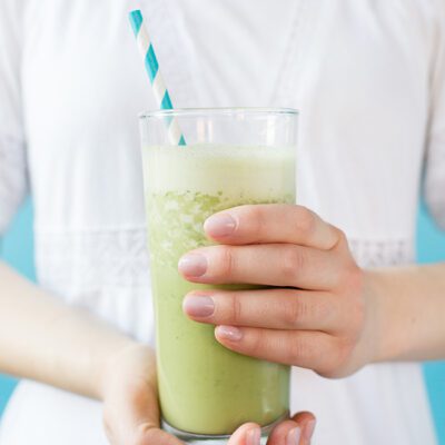 Woman in white dress holding smoothie